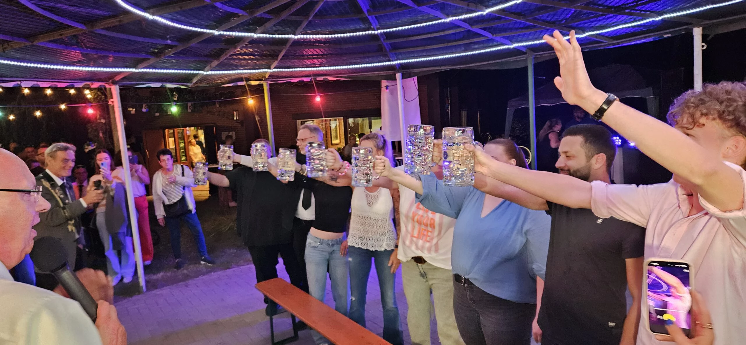 Gäste beim Bierkrugstemmen auf der Open-Air-Disco beim Schützenfest
